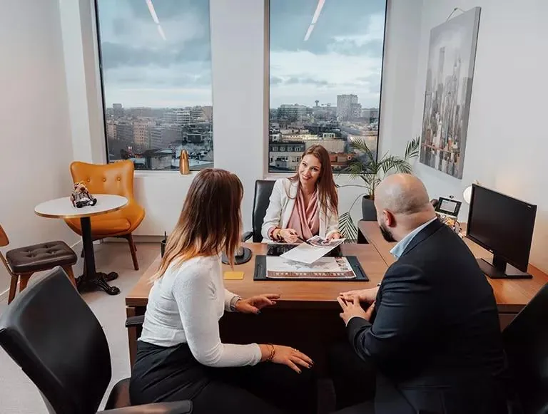 Rendez-vous entre une traductrice et deux clients autour d’un bureau